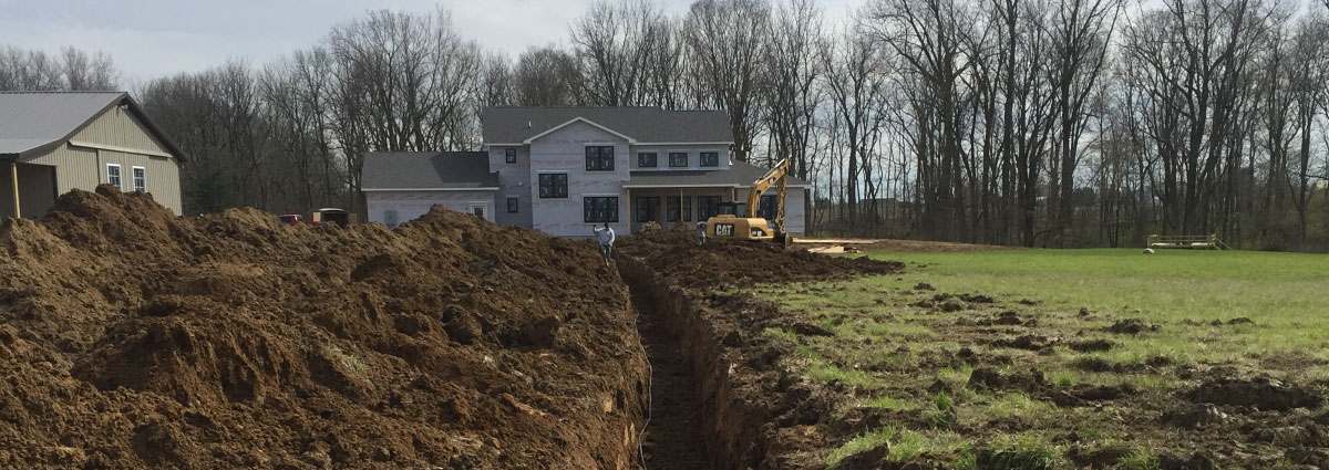 The team at My Guys laying geothermal loop into a trench dug for a geothermal system installation.